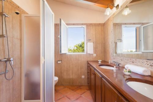 a bathroom with a sink and a toilet and a mirror at Villa Blancala 502 in Cala Santandria
