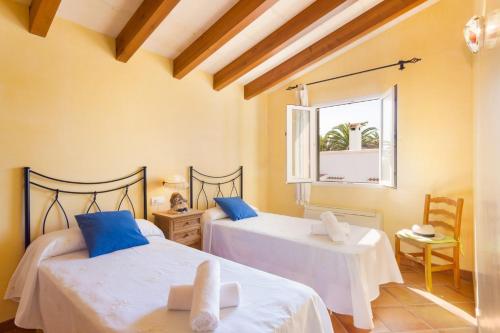 a bedroom with two beds and a window at Villa Blancala 502 in Cala Santandria