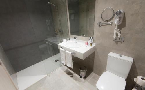 a bathroom with a toilet and a sink and a mirror at Dos Playas - 30º hotels in Puerto de Mazarrón