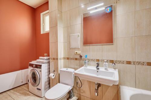 a bathroom with a toilet sink and a washing machine at Botanic Towers the house has a shelter in Kyiv