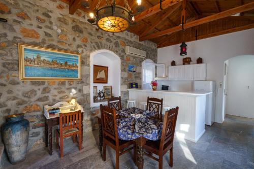 eine Küche und ein Esszimmer mit einem Tisch und Stühlen in der Unterkunft Villa Mandraki in Hydra