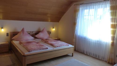 a bedroom with a bed with pink pillows and a window at Ferien Apartment Melcher in Zeltingen-Rachtig