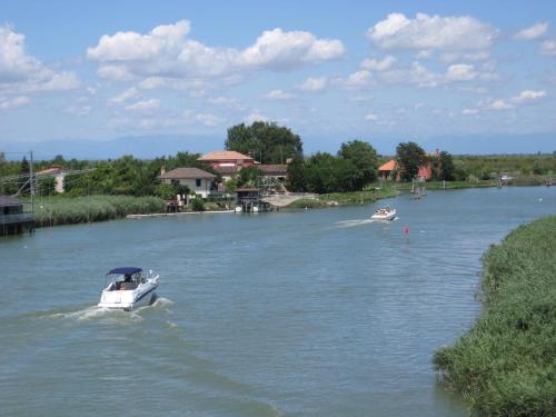 un bateau blanc sur une rivière avec deux autres bateaux dans l'établissement B&B Garnì Da Vito, à Lido di Jesolo