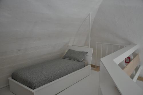 a small bedroom with a bed in a white room at La Sassolina appartamento in Matera