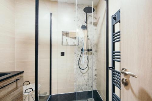 La salle de bains est pourvue d'une douche avec une porte en verre. dans l'établissement The Rhuys - Cosy-balcony with superb Loire view - all on foot - Parking, à Nantes