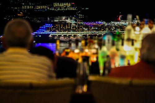 a group of people sitting at a table with a cruise ship at The Mafolie Hotel in Mafolie