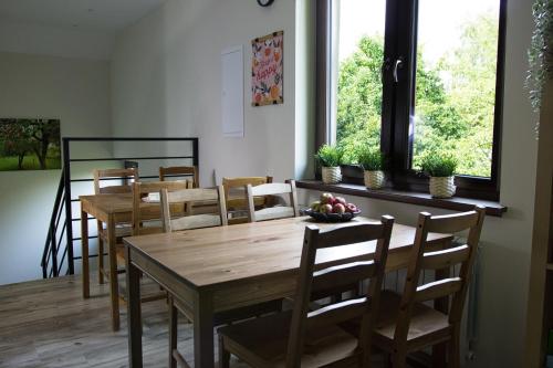 a dining room with wooden tables and chairs and a window at Barwald Hills - jacuzzi i piękny widok na Babią Górę i Beskidy in Wadowice