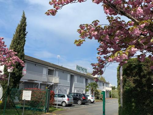 a hotel with cars parked in a parking lot at Fasthotel Tours Nord in Parçay-Meslay