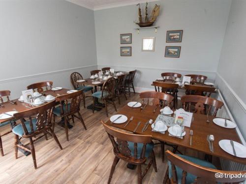 a dining room with wooden tables and chairs at The Beeches in Clacton-on-Sea