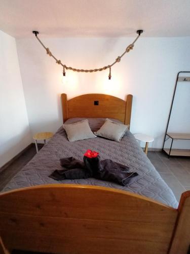 Le Hamel的住宿－GITE COCOONING LE HAMEL，一间卧室配有一张大木床,床上有红花