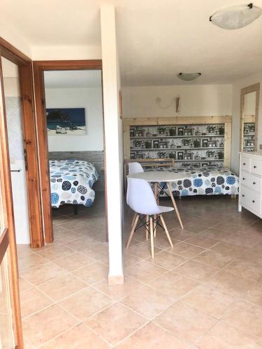 a living room with a table and a bed at B&B Tavolara in Puntaldia