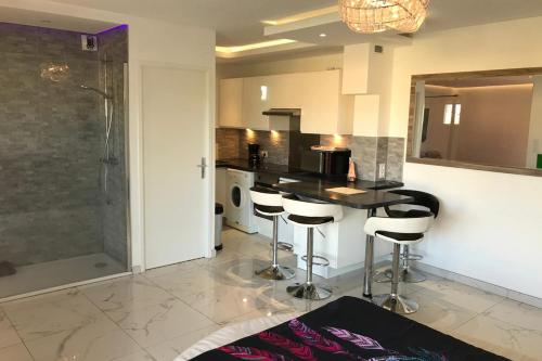 une cuisine avec un comptoir et des tabourets de bar dans l'établissement Naturiste Cap d'Agde Natura Beach 111, au Cap d'Agde