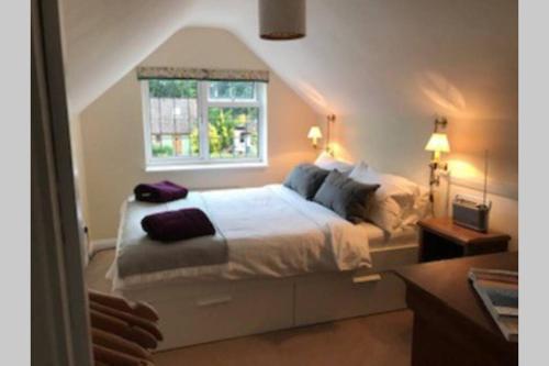 a bedroom with a large bed with a window at Rose Cottage in Lymington