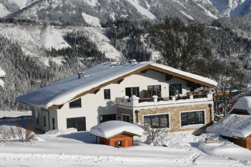 a house covered in snow with mountains in the background at Haus Bergliebe in Schladming