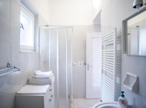 La salle de bains blanche est pourvue de toilettes et d'un lavabo. dans l'établissement Villa Mori, à Levanto