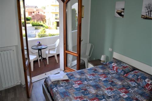 sypialnia z łóżkiem i stołem oraz balkonem w obiekcie Mattia's House on Garda Lake w mieście Peschiera del Garda