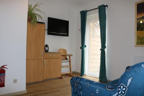 a living room with a blue couch and a window at Ferienhof Gruber in Schrattenbach
