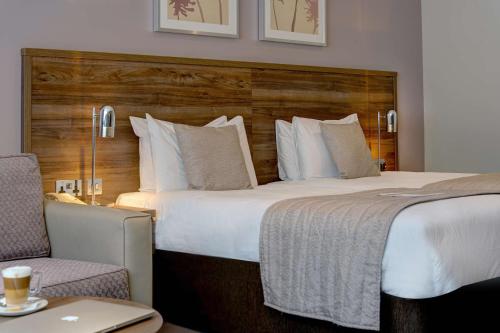 a hotel room with a large bed and a chair at Best Western Ship Hotel in Weybridge