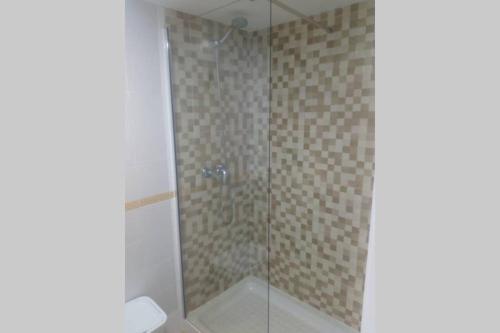 een badkamer met een douche met een glazen deur bij Apartamento Soleado in Tarifa