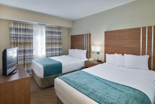 A bed or beds in a room at Hawthorn Suites by Wyndham Naples