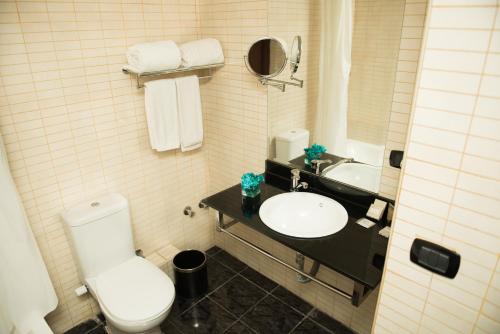 
a white toilet sitting next to a sink in a bathroom at Cherry Maryski Hotel in Alexandria
