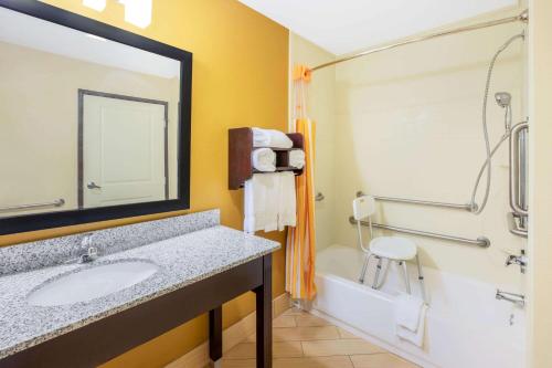 Un baño con lavabo, ducha y bañera. en La Quinta by Wyndham Floresville, en Floresville
