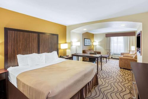 Una habitación de hotel con una cama grande y una sala de estar. en La Quinta by Wyndham Floresville, en Floresville
