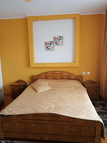 a bed in a bedroom with a picture on the wall at Pensiunea Lucia Ana in Cluj-Napoca