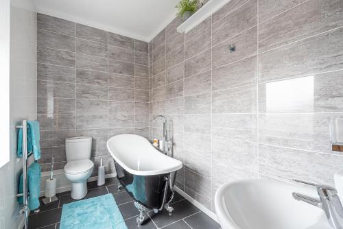 a bathroom with a sink and a toilet and a tub at Dales Edge - Skipton in Skipton
