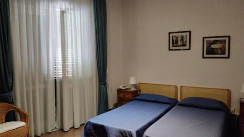 a bedroom with a bed and a window with curtains at Hotel Caporal in Minori