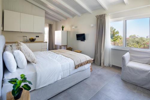 um quarto com uma cama, uma cadeira e uma janela em s u e ñ o - studios and apartments, with shared pool em Kato Daratso