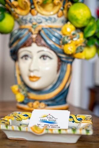 a vase with a statue of a woman on a table at Vista Mare Apartments in Giardini Naxos