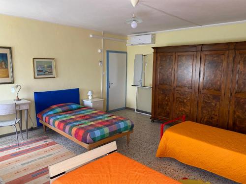 Habitación pequeña con 2 camas y escritorio. en Ca' Basilio, en Taglio di Po