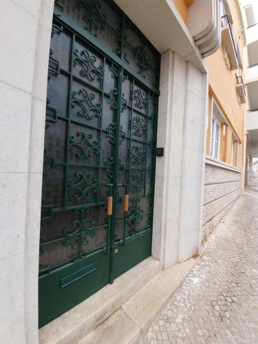 una puerta verde al lado de un edificio en Inn Faro - Casa Amarela - Guest House en Faro