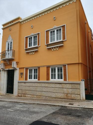 un bâtiment jaune avec des fenêtres et une porte dans l'établissement Inn Faro - Casa Amarela - Guest House, à Faro