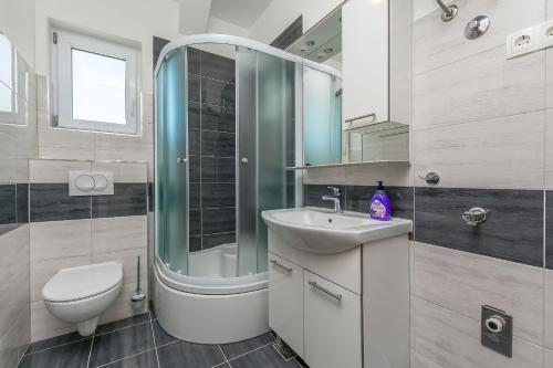 a bathroom with a shower and a sink and a toilet at Apartments Kate in Duće