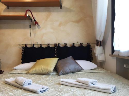 ein Bett mit zwei Kissen und Handtüchern darauf in der Unterkunft CASA Lux in Serravalle Pistoiese