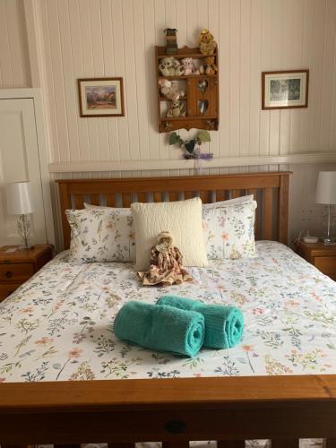 a bed with a teddy bear and towels on it at Cherry Blossom Cottage-with country charm and spa in Stanthorpe