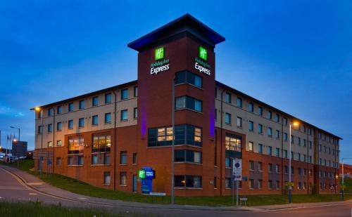 a building with green lights on the top of it at Holiday Inn Express London Luton Airport, an IHG Hotel in Luton