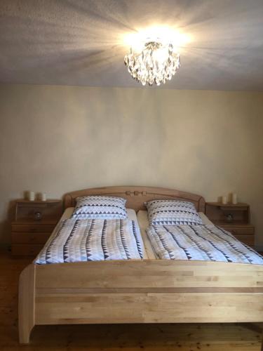 a bed in a bedroom with a chandelier at Ferienhaus in Sankt Aldegund