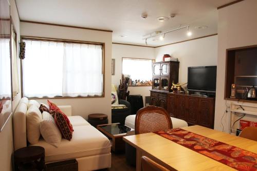 a living room with a couch and a tv at HAMA HILLS Shinjuku in Tokyo