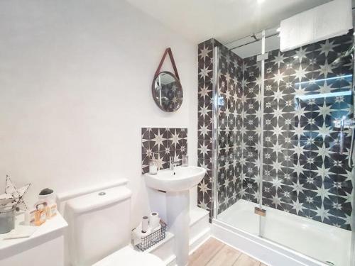 a white bathroom with a sink and a shower at 7 Grove Farm Barns in Sculthorpe