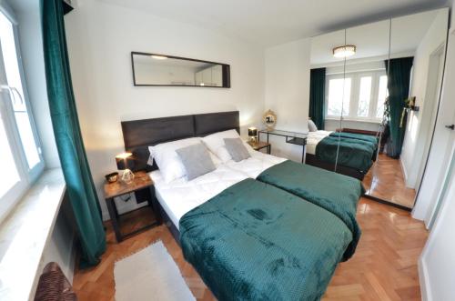 1 dormitorio con cama, mesa y espejo en Apartament z Dwoma Sypialniami, en Malbork