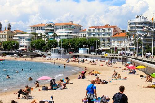 a group of people on a beach near the water at Nouvel Hotel in Saint-Raphaël
