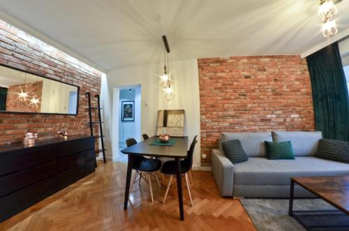 a living room with a couch and a brick wall at Apartament z Dwoma Sypialniami in Malbork