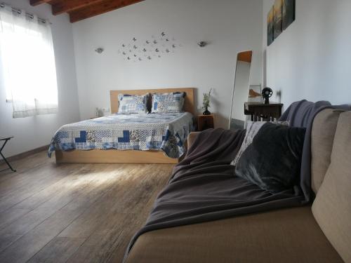 Un dormitorio con una cama y un sofá. en Casa da Paraventa, en Gaieiras