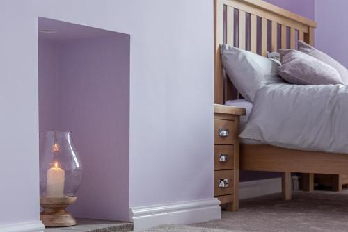 a bedroom with a bed and a candle next to a table at Dales Edge - Skipton in Skipton