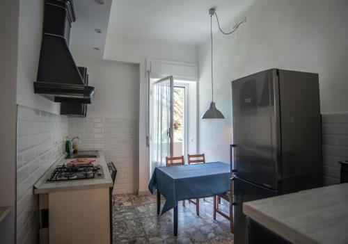 a kitchen with a refrigerator and a table in it at Appartamento Arcobaleno in Levanto