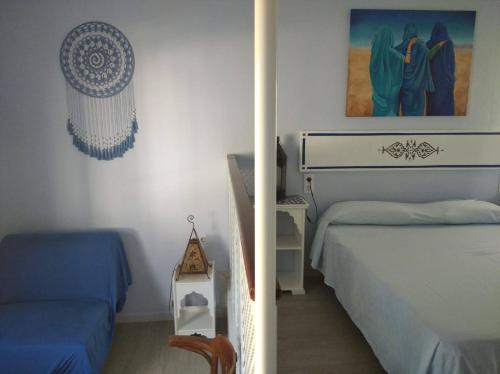 サンルーカル・デ・バラメダにあるEl apartaitoのベッドルーム1室(ベッド2台、テーブル、写真付)