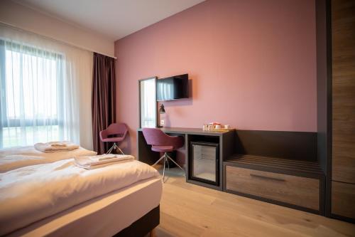 a hotel room with a bed and a desk at A22 Hotel Gyál in Gyál